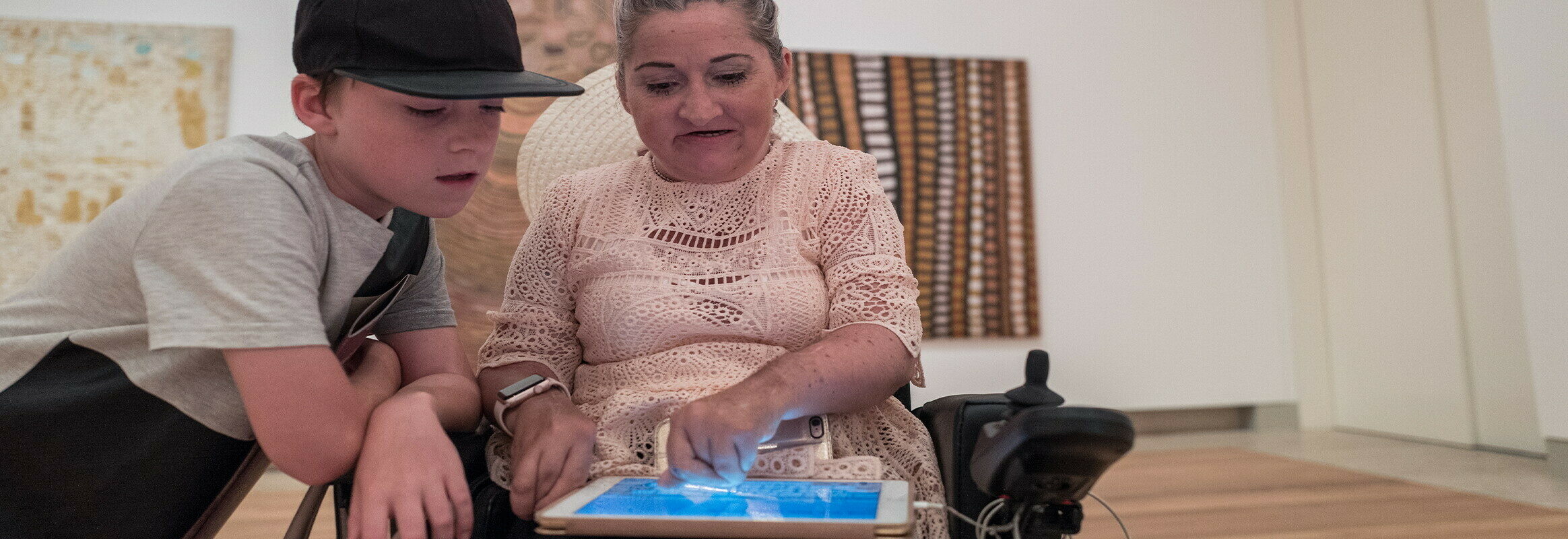 Lisa schrijft op haar iPad terwijl haar zoon leest wat ze schrijft