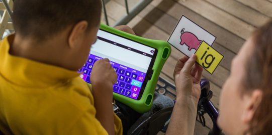 Young boy communicating using iPad with AAC system