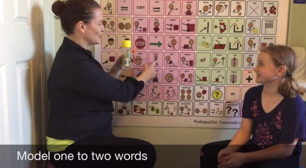 Amanda modelling the word Look on a large core word board to child with speech impediments