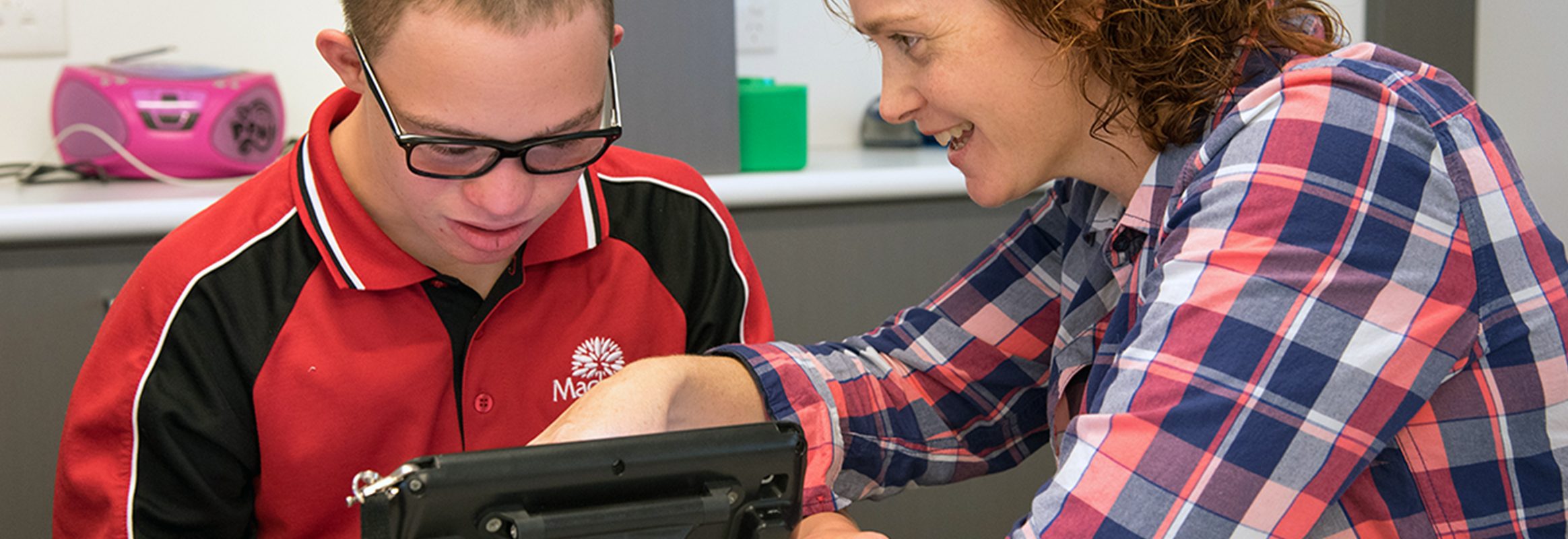 Boy learning and communicating through iPad with teacher