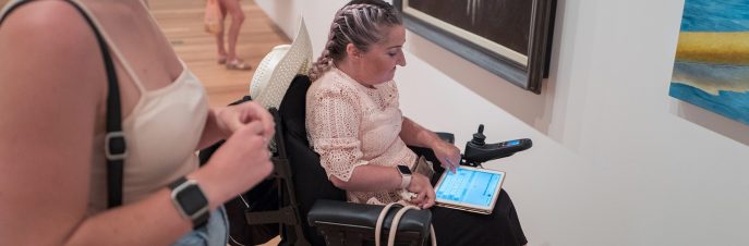 Lisa using Proloquo4Text in an art gallery to talk with her friend