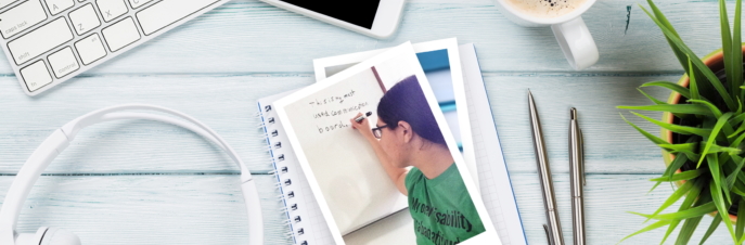 Keyboard, pen and notepad with photo of author Alyssa Hillary on table