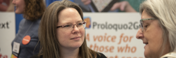 Erin Sheldon at conference speaking to someone