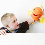 Boy holding orange fish hand puppet