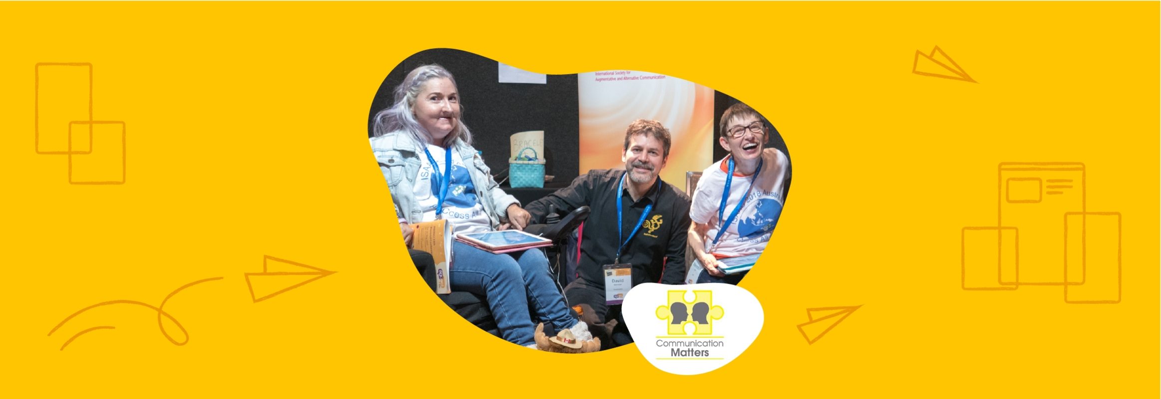 A wheelchair user and two non-users are looking at the camera. They're set on a yellow background with the "Communication matters" logo in the lower right corner