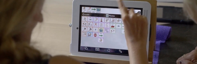 Girl pointing finger at iPad with Proloquo2Go