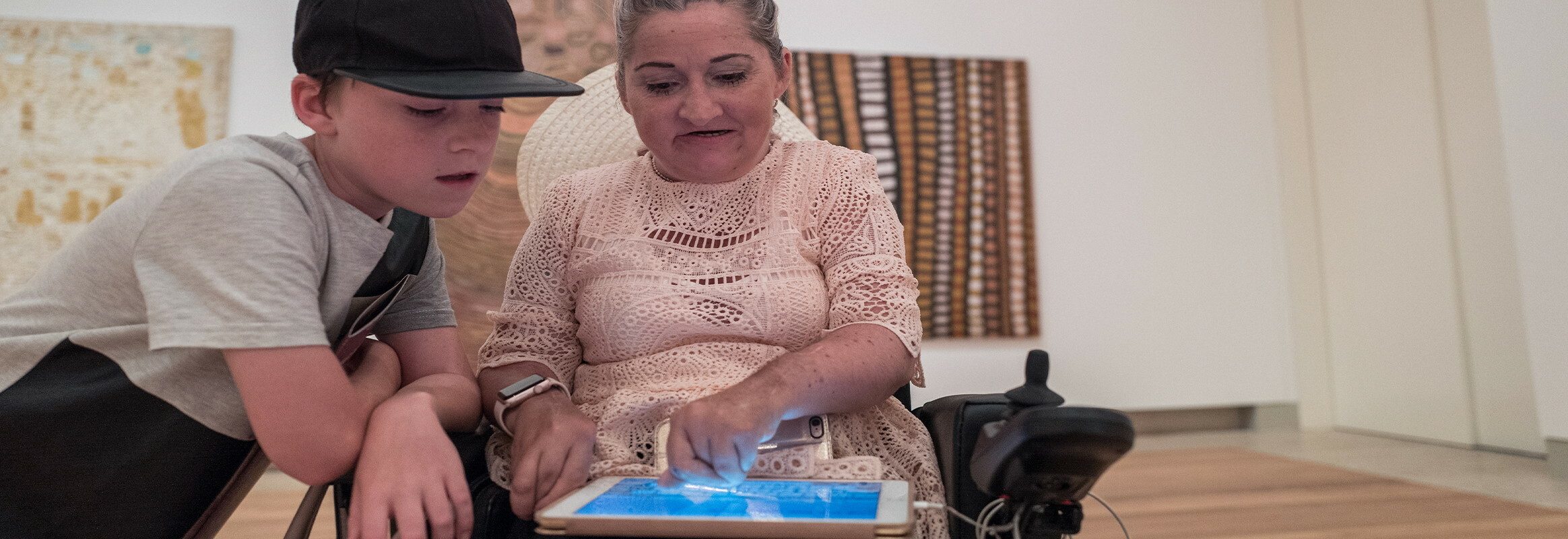 Lisa writes on her iPad while her son reads what she writes