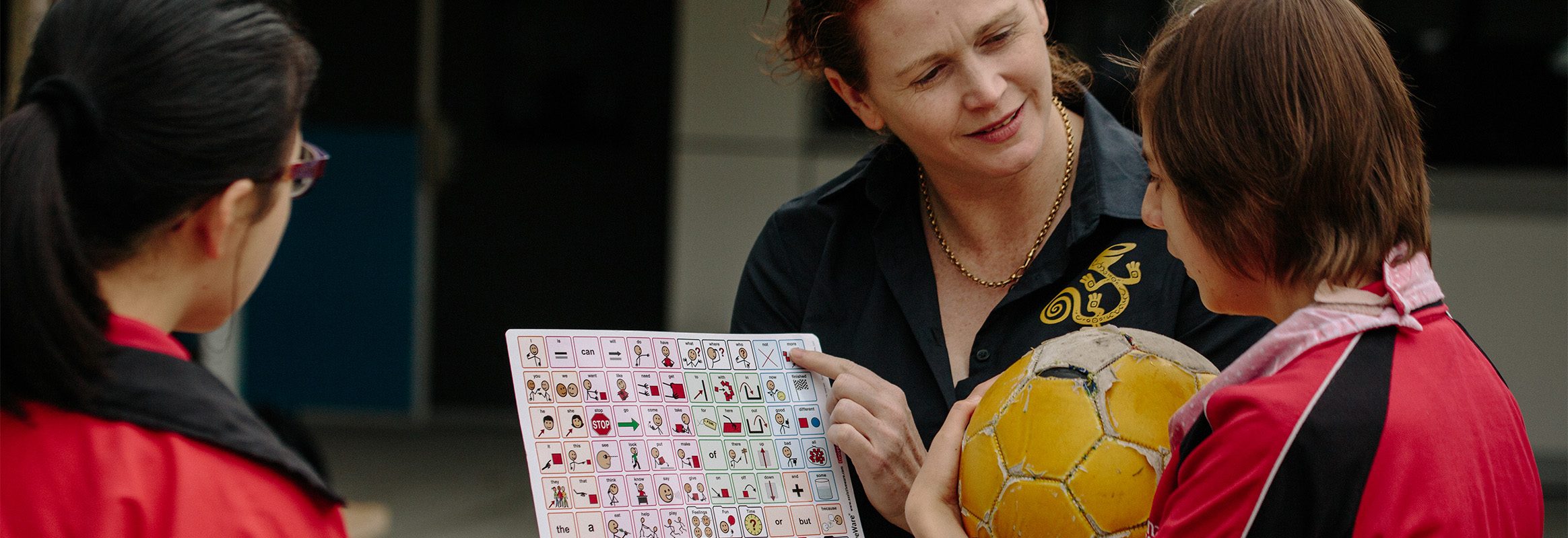 Young girl with soccer ball learning with core words board