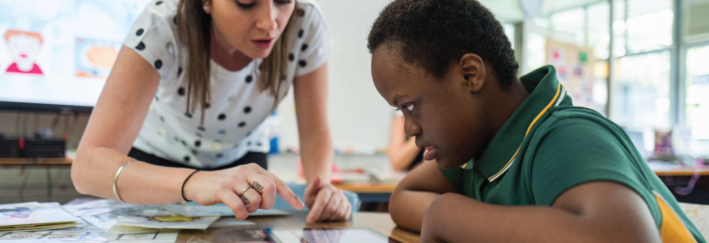 Teacher points to iPad while student looks at what she is pointing to