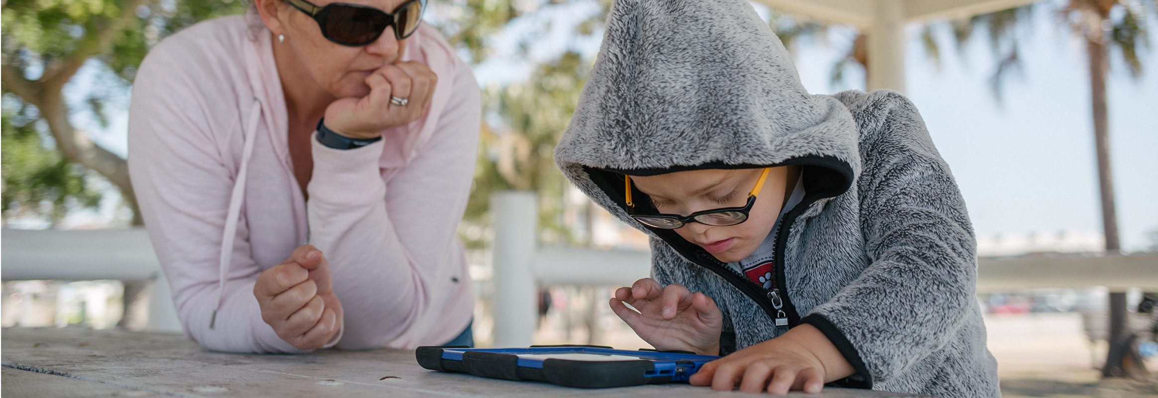 Young boy using iPad outside