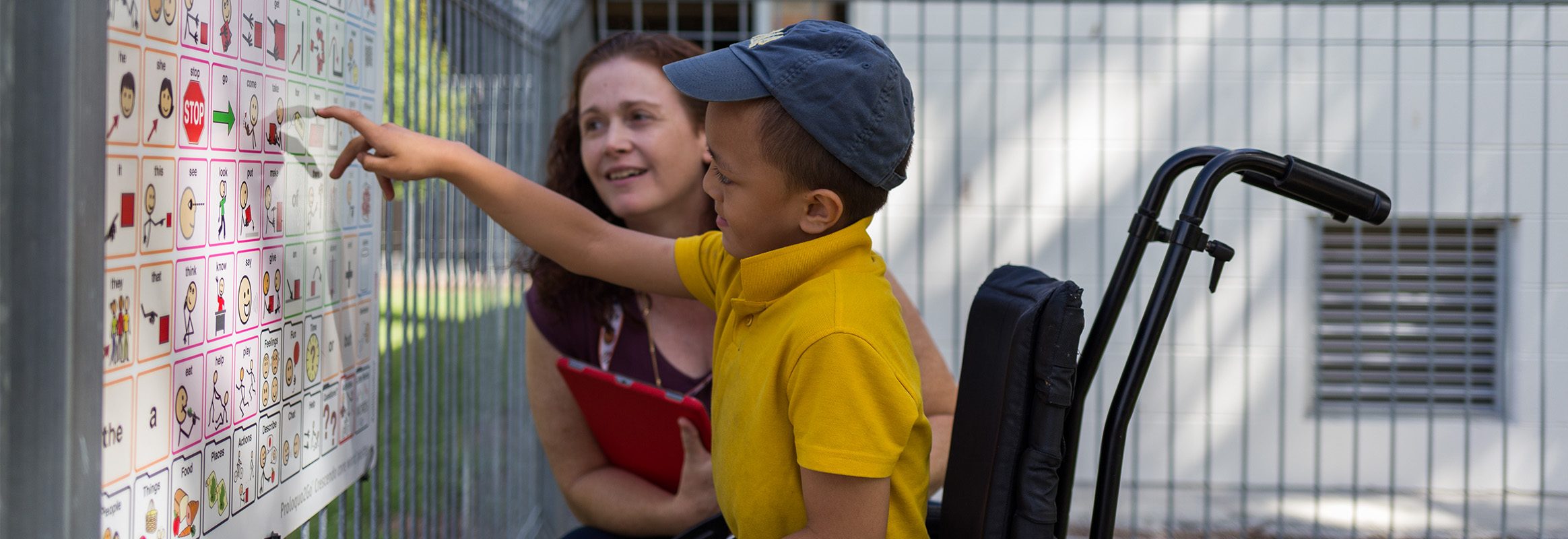 Young boy pointing to a Core Words board