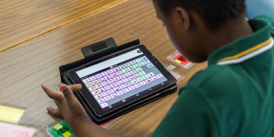 Young boy typing on iPad