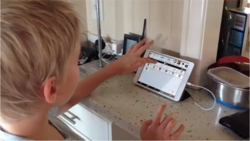 Boy using AAC system on iPad