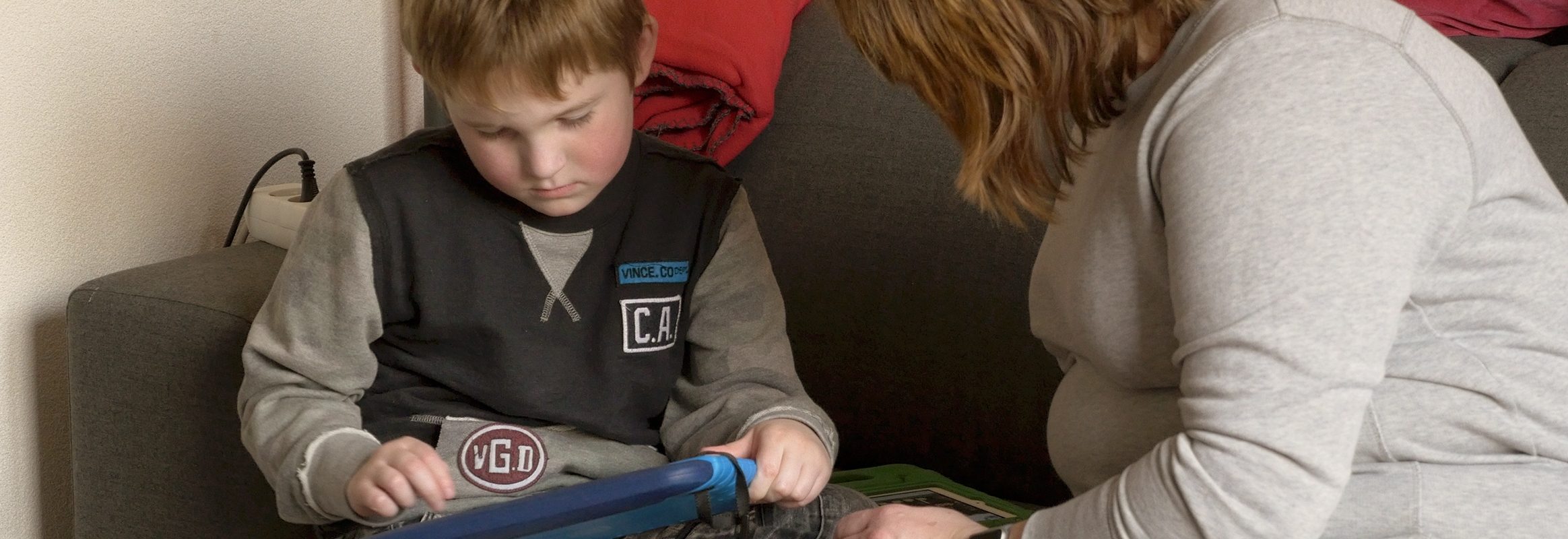 Hugo with iPad on the coach with his mother Martine