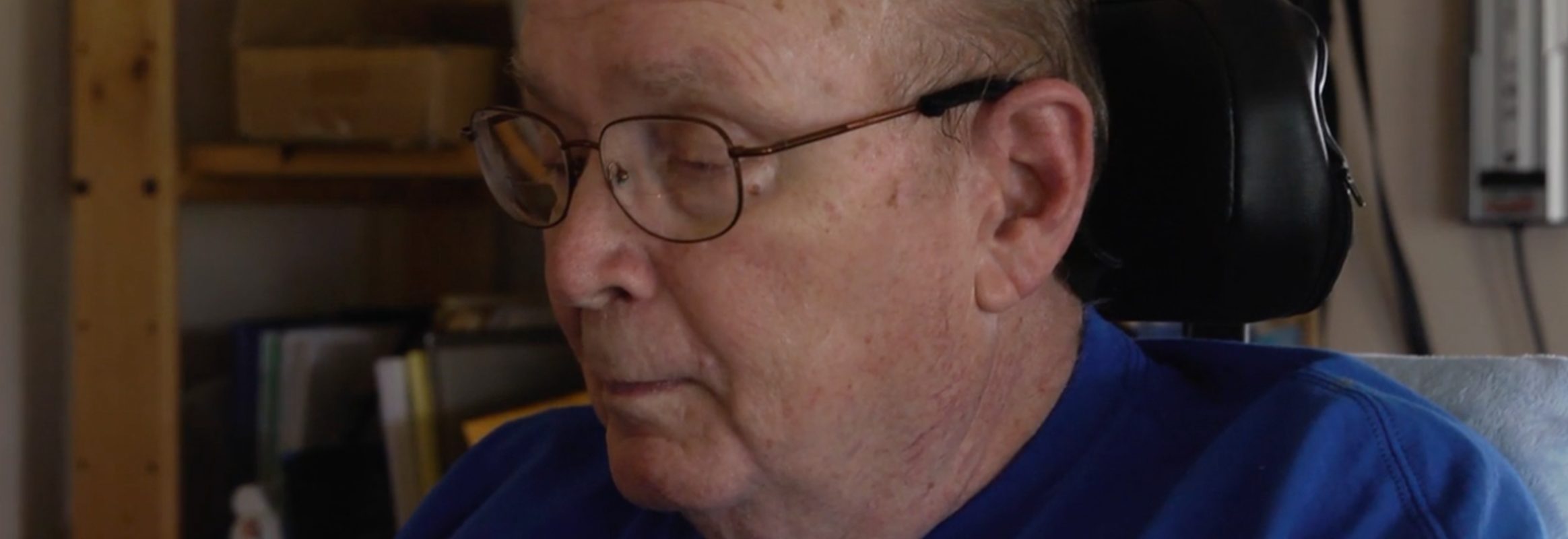Elderly man with glasses sitting