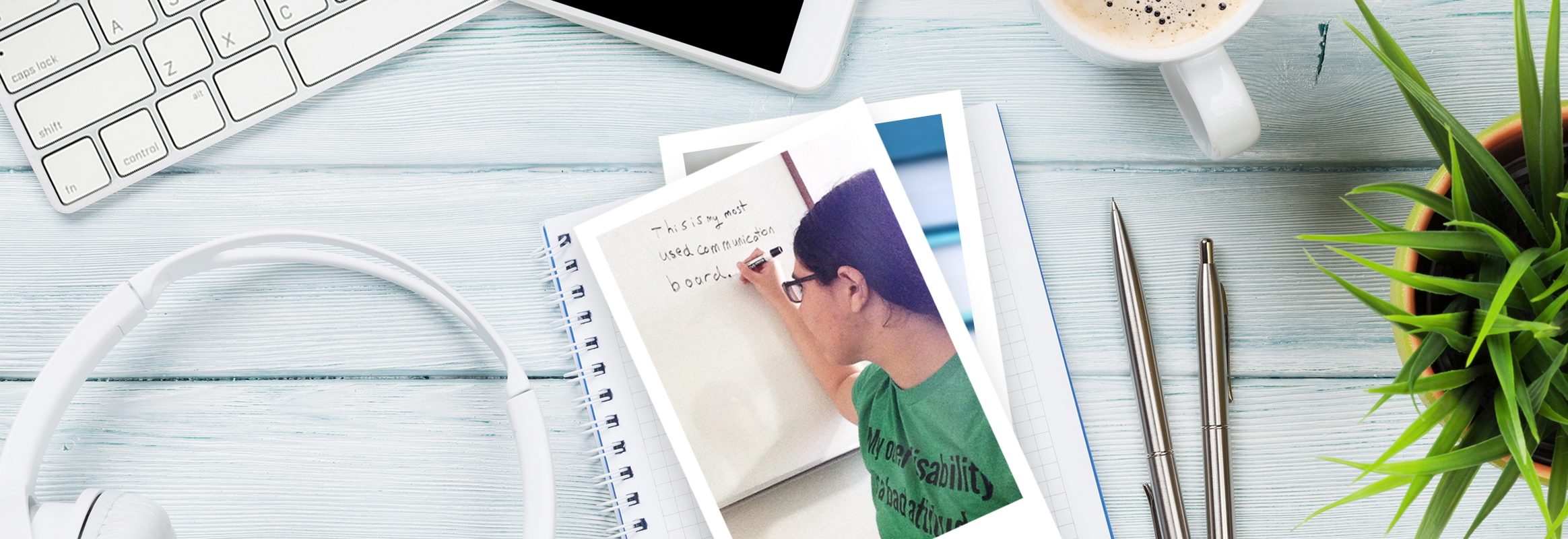 Keyboard, pen and notepad with photo of author Alyssa Hillary on table