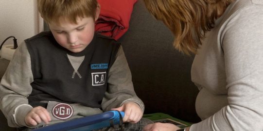 Hugo with iPad on the coach with his mother Martine