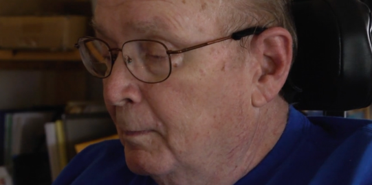 Elderly man with glasses sitting