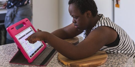 Girl using Proloquo2Go on an iPad