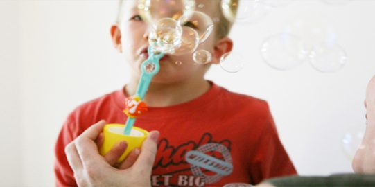 Young boy blowing bubbles