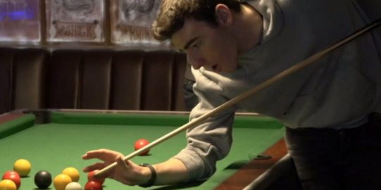 Ben plays pool with a mate