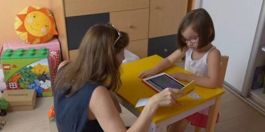 Young girl with iPad and teacher