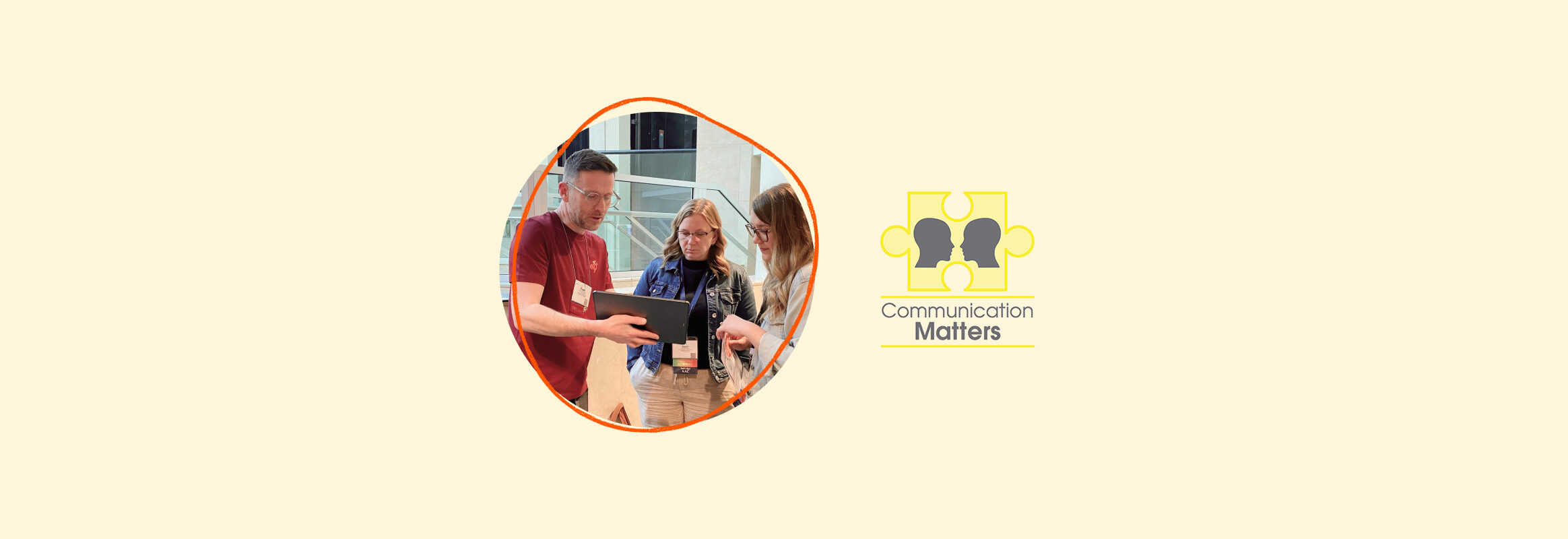 Communication Matters logo with image of Euan showing two SLPs something on his iPad