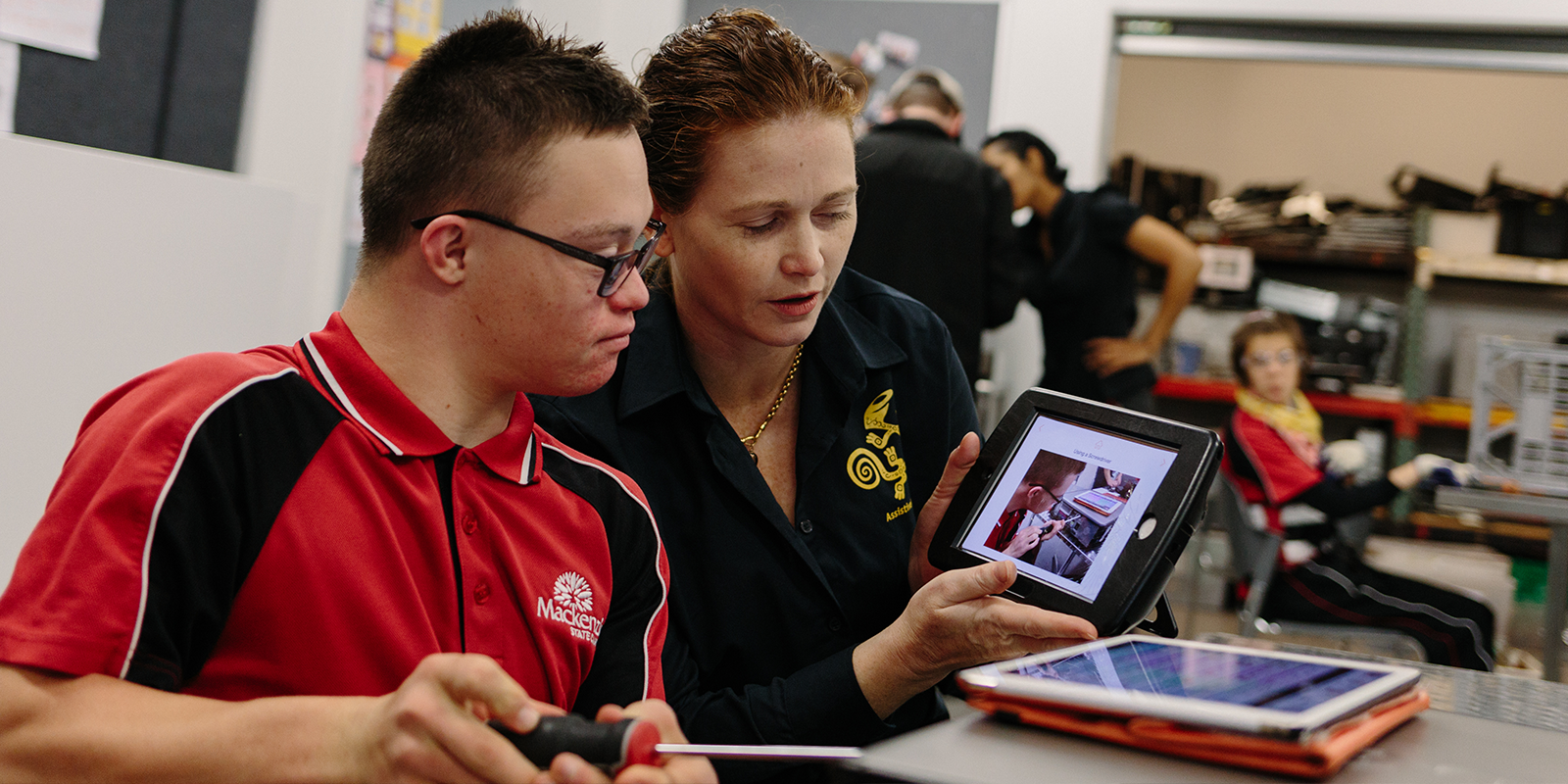 Lerares toont iPad aan leerling