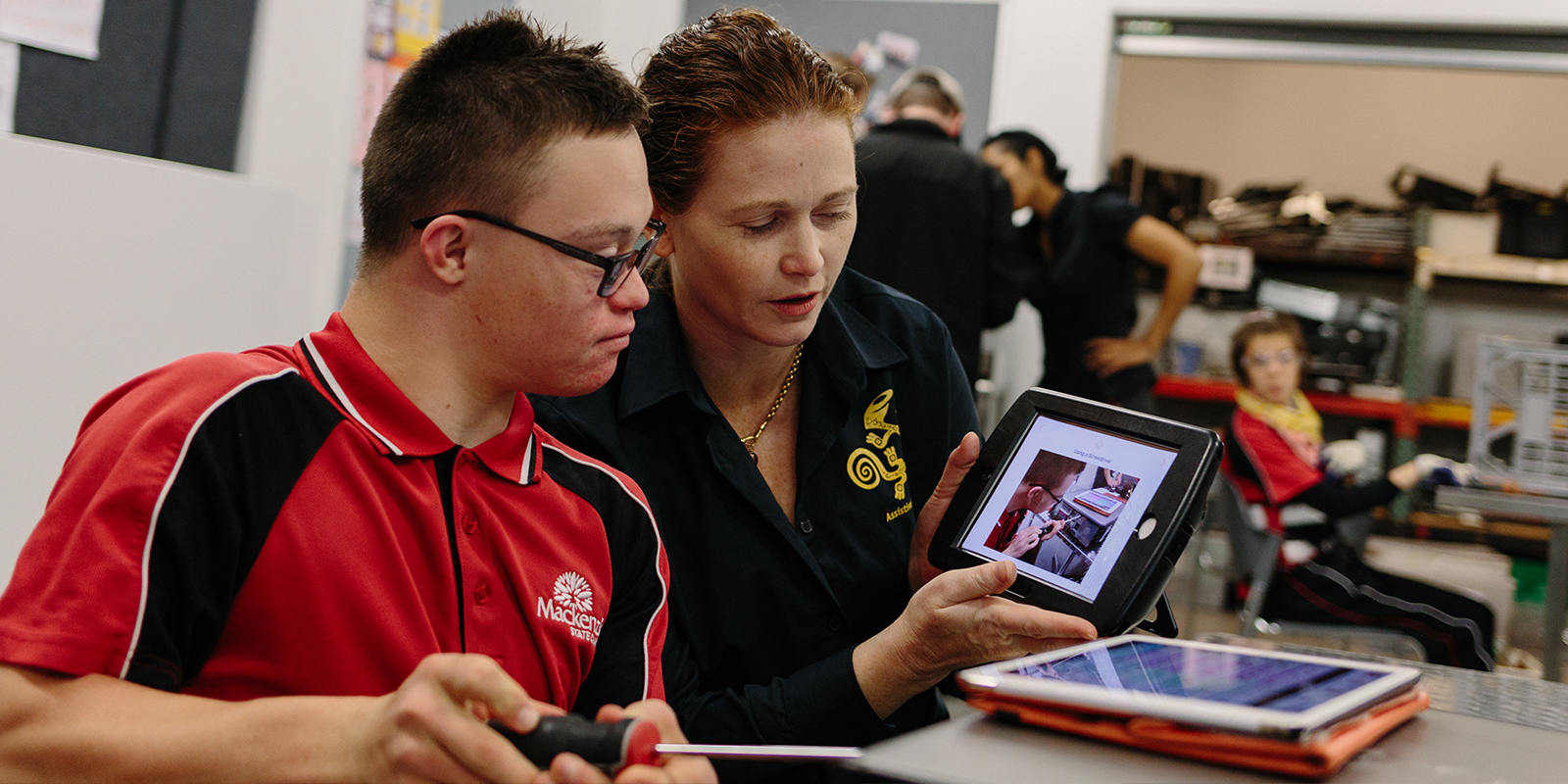 El profesor muestra iPad a alumno