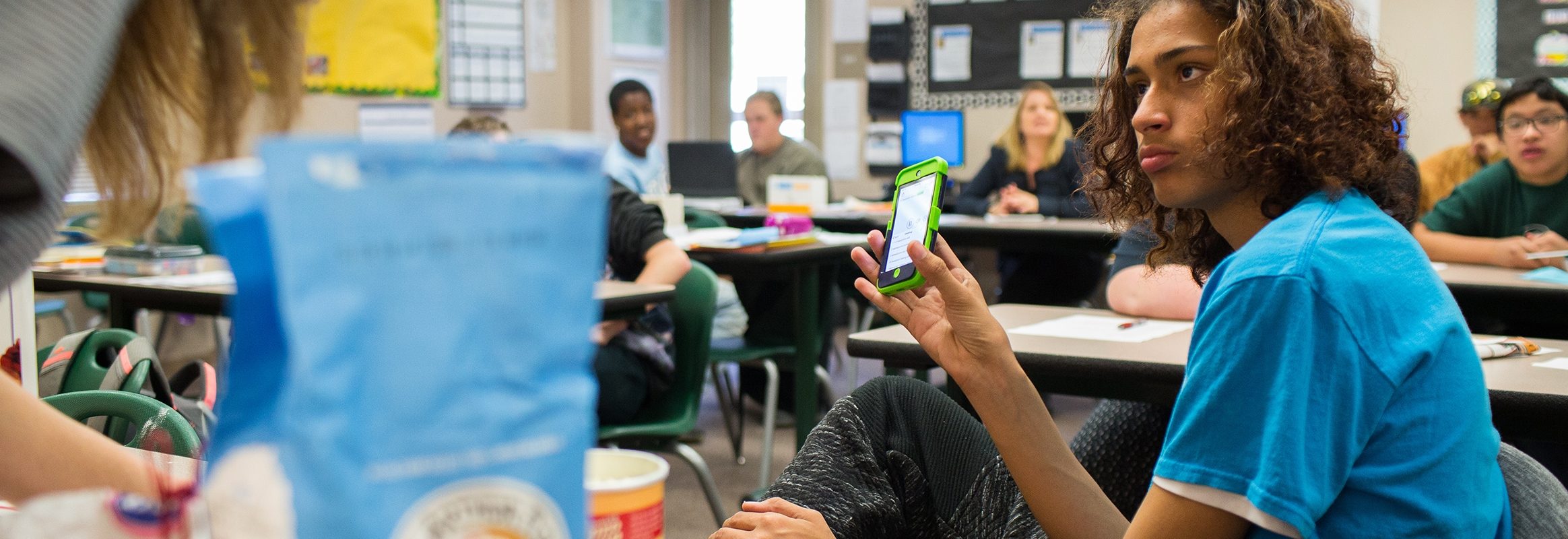 Boy using iPhone in classroom
