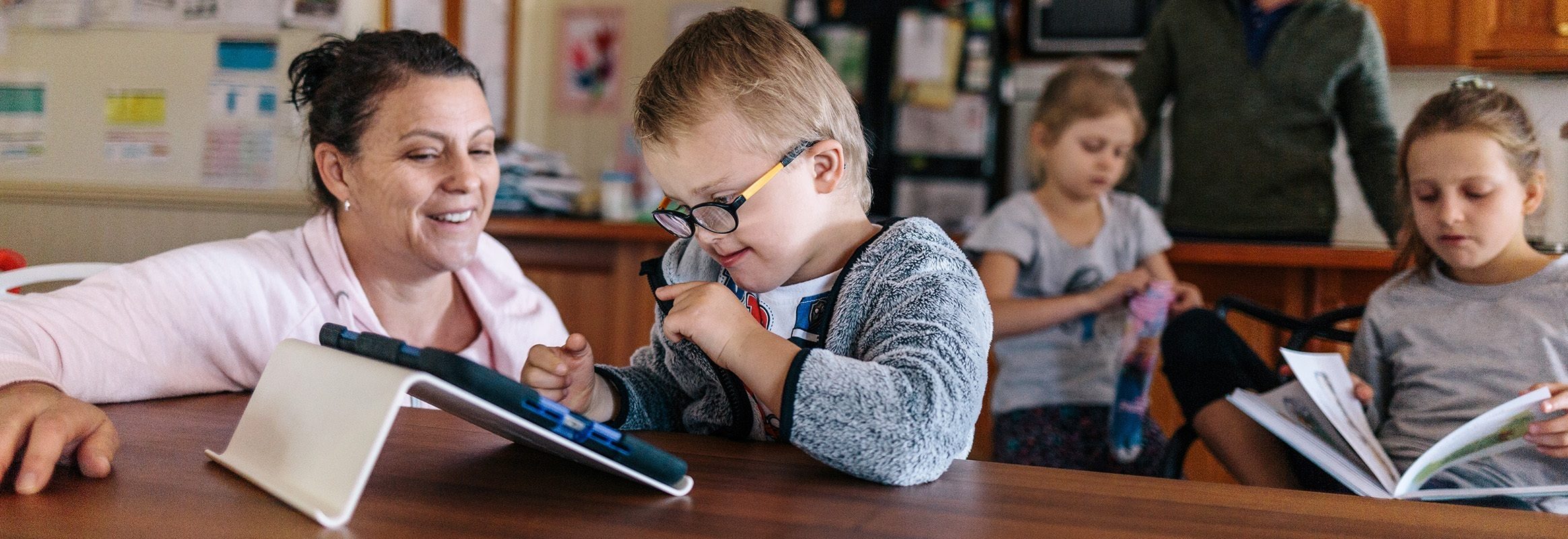 Niño y profesor con iPad en el aula